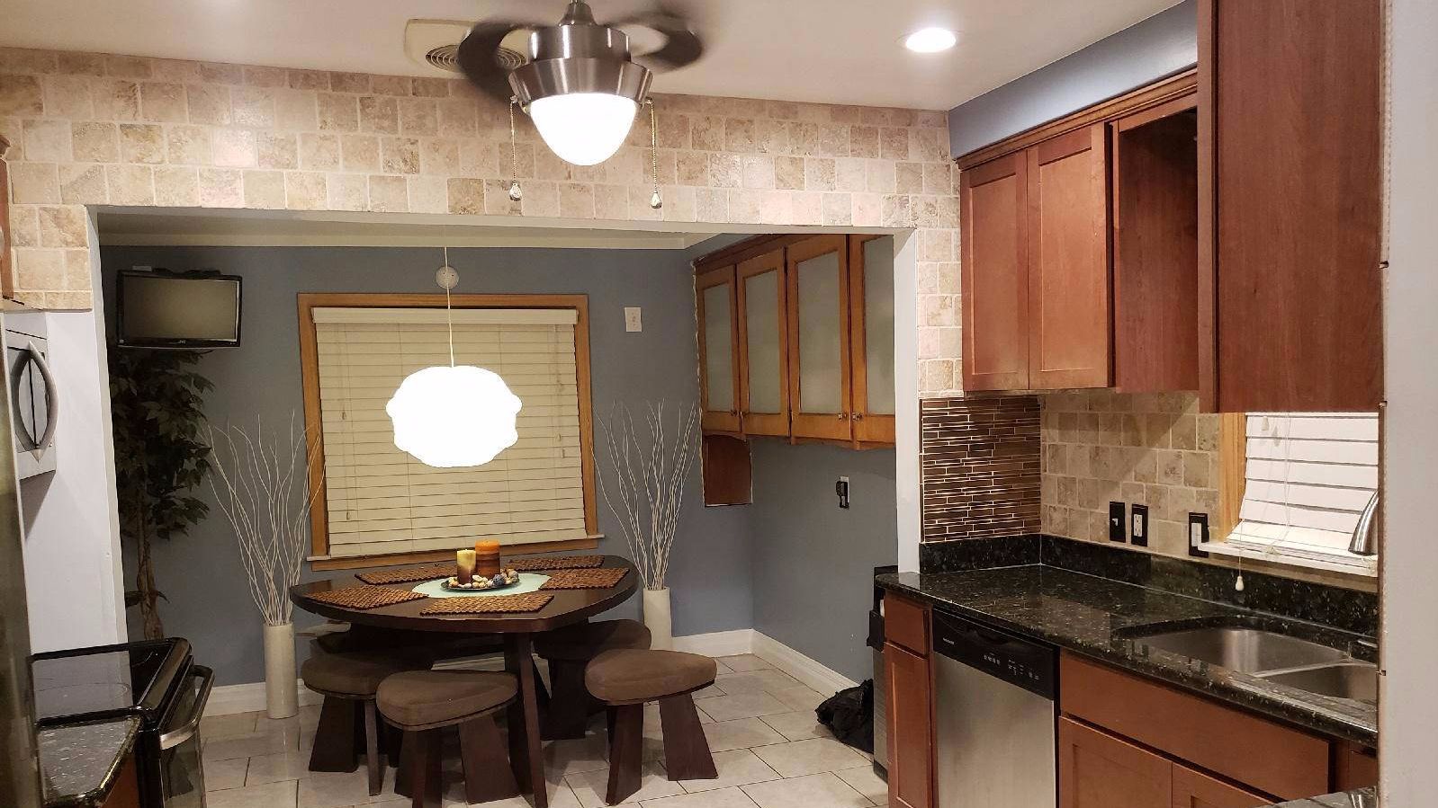 Kitchen remodel opening onto a dining nook, with cherry cabinets and tile floor